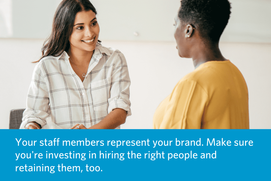 two women sitting and talking with each other with quote to right: Your staff members represent your brand. Make sure you're investing in hiring the right people and retaining them, too.