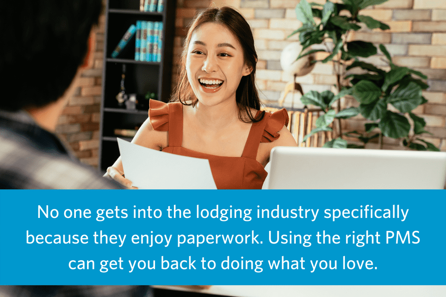 image of a smiling woman standing behind a hotel front desk talking with a guest