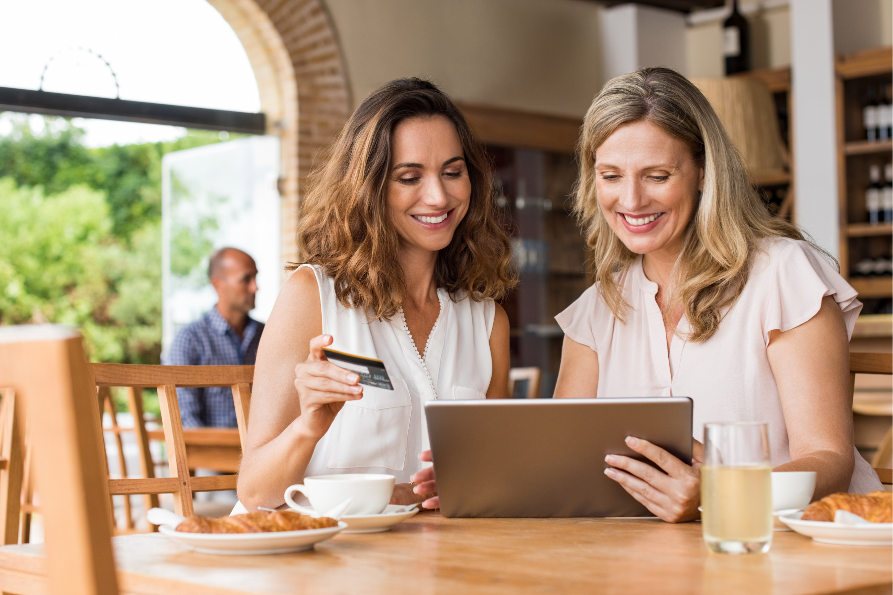 A couple entering credit card info on a tablet.