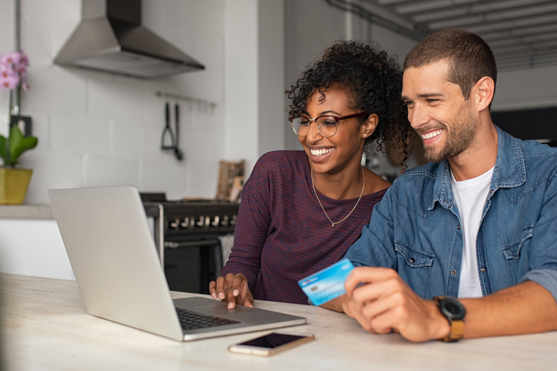 A couple entering credit card info on a laptop.