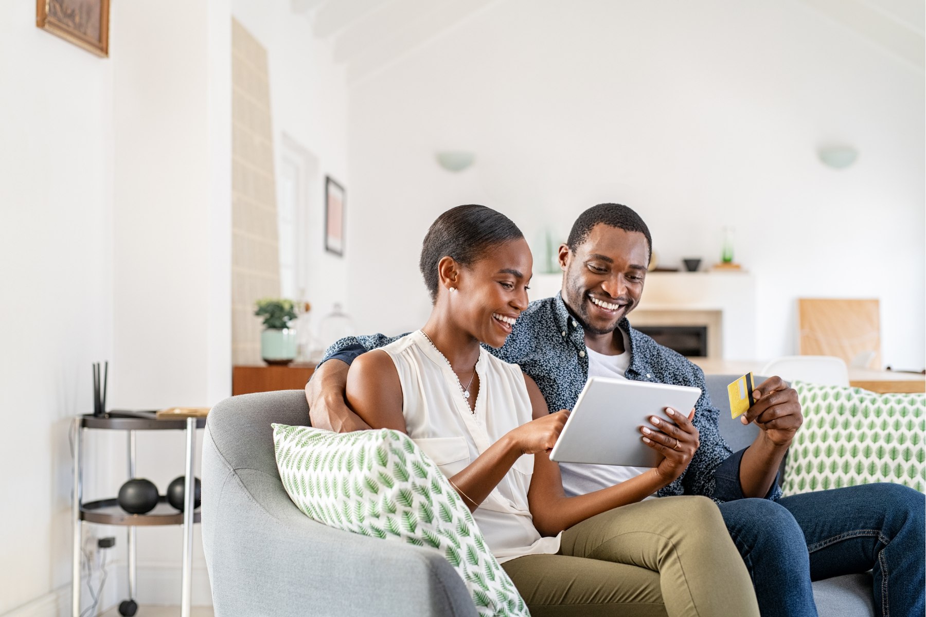 A couple entering credit card info on a tablet.